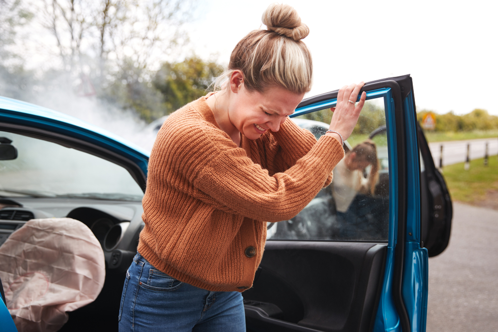 Woman showing signs of neck injury after car accident