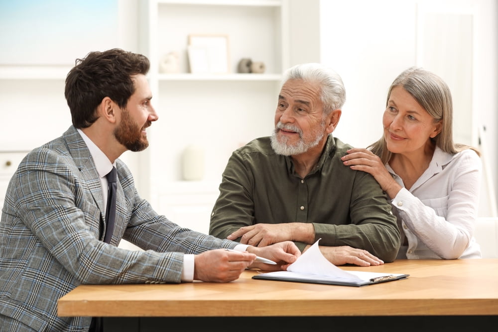 attorney meeting with older couple, advising about their rights with documents on the table